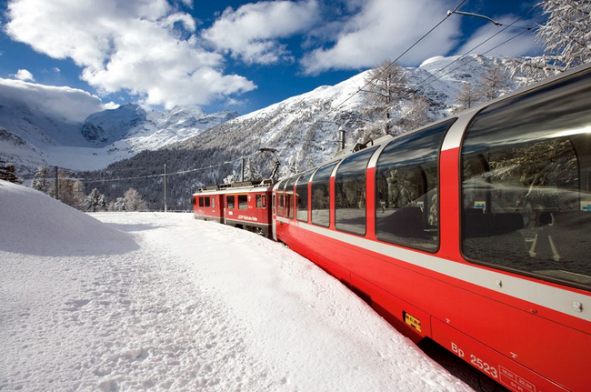 Il trenino del Bernina rosso fuoco sulla neve bianca